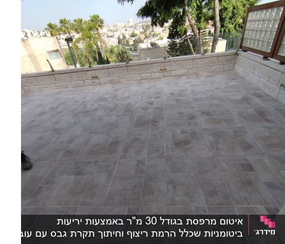 ריצוף חדש על מרפסת עם קיר אבן